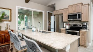 A modern kitchen with a large island, stainless steel appliances, and light wood cabinetry. - The All-Suite Century Oak House - Steps to Remi's Ridge & Hayes Hollow (Spring Branch)