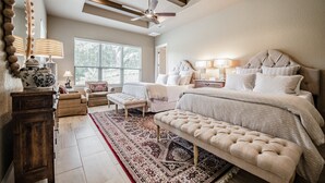 A bedroom with a large bed, a bench, a ceiling fan, and a window with blinds. - The All-Suite Century Oak House - Steps to Remi's Ridge & Hayes Hollow (Spring Branch)