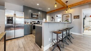 A modern kitchen with stainless steel appliances, grey cabinets, and a wooden ceiling. - Serene property with two living spaces and large outdoor space - dog-friendly (Wimberley)