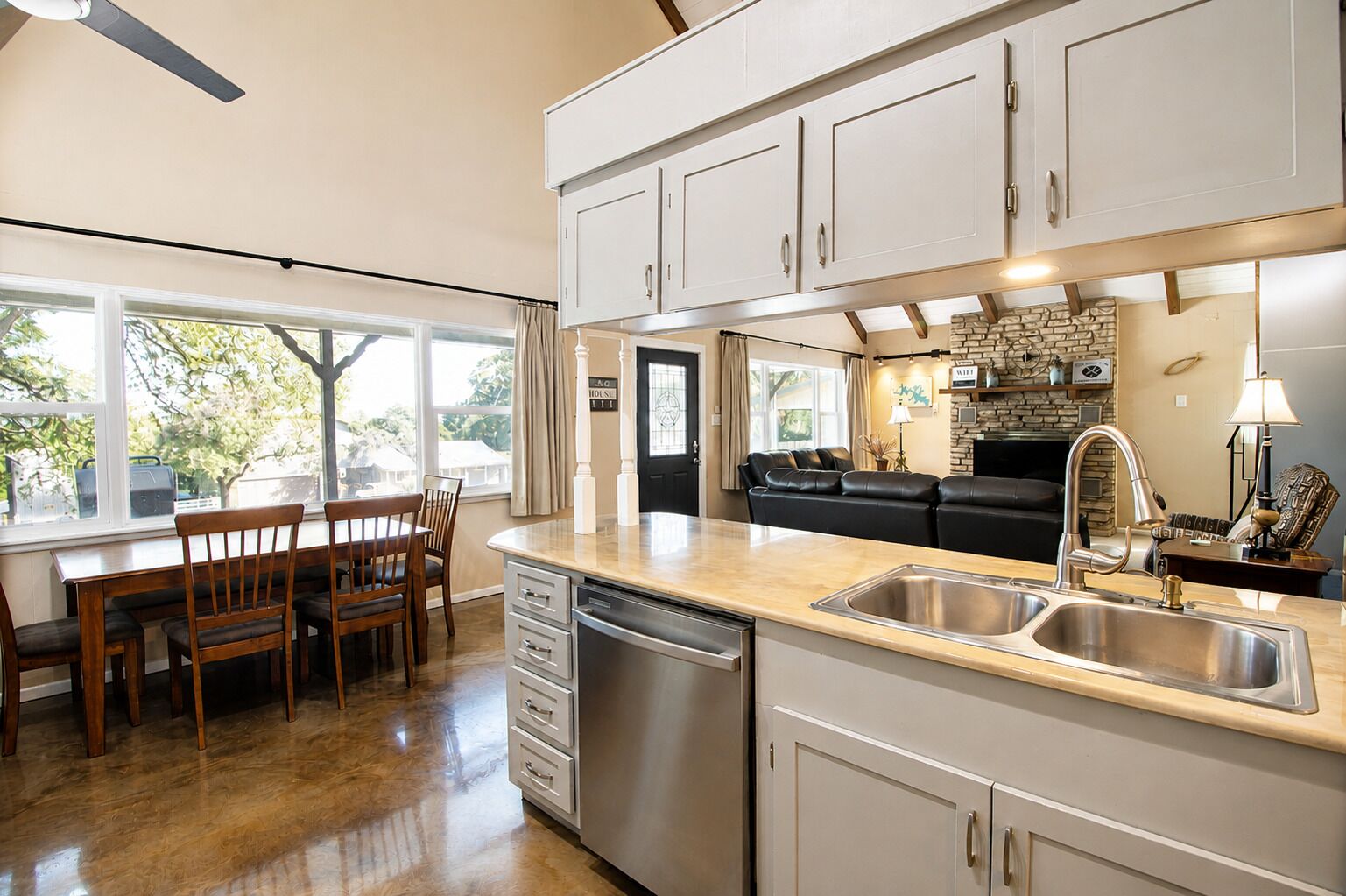 Una cocina moderna con comedor, muebles empotrados, lavavajillas y chimenea de piedra.