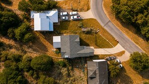 Vue aérienne d’un quartier résidentiel avec une maison, une allée et des voitures garées.
