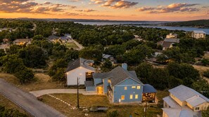Un quartier résidentiel avec des maisons, une route et une étendue d’eau en arrière-plan.