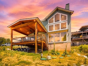 A two-story house with a wooden deck, large windows, and a covered porch. - Lakeside Serenity with Private Waterfront Access on Canyon Lake (Canyon Lake)