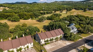 Una zona residencial con hilera de casas, una calle y vegetación circundante.