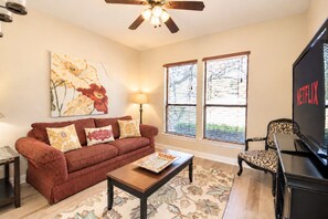 A living room with a sofa, coffee table, and a TV. - Stargazers' dream home on 1.5 acres w/ telescope-near wineries-Dogs ok (Dripping Springs)