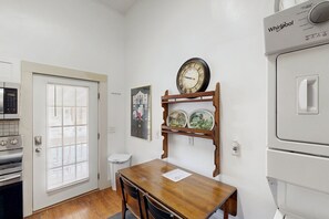 A kitchen with a white refrigerator, a microwave, and a wooden table with chairs. - Downtown duplex with patio, enclosed backyard, washer/dryer, streaming, AC, WiFi (San Antonio)