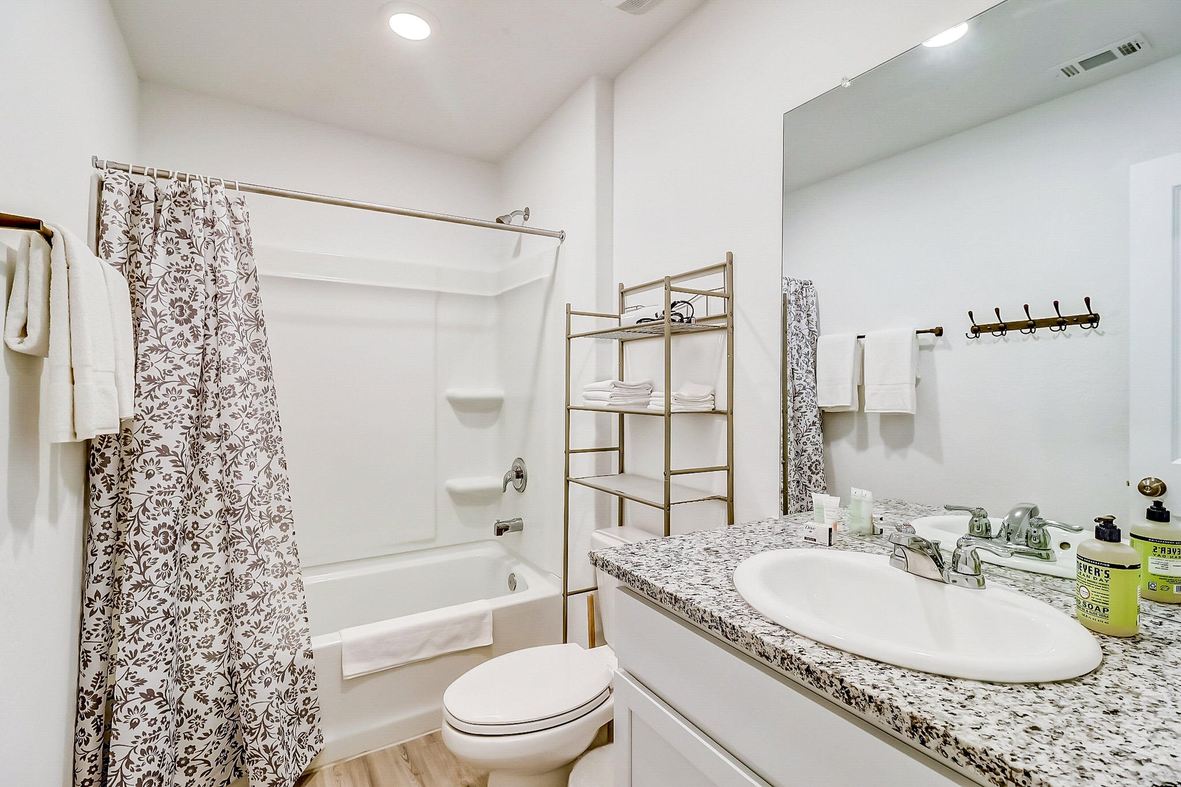 Un baño moderno con bañera, inodoro y lavabo con espejo.