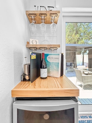 A bar area with a wine bottle, glasses, and a welcome sign. - Cozy Coastal 3-Bedroom Bungalow Near the Beach (Holmes Beach)