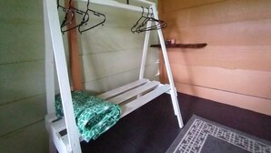 Un lit superposé avec une structure blanche et une couverture à motifs verts.