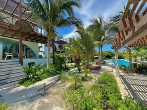 Un resort con piscina, palmeras y un paseo techado.