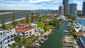 A coastal residential area with modern buildings, a marina, and a river. - Canal Luxury living & boat ramp (Runaway Bay)