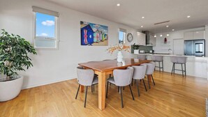 Eine moderne Küche mit einem Holztisch, grauen Stühlen und einem Blumentopf.