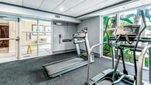 A gym with treadmills, a stationary bike, and a weight bench. - Lakefront condo with amazing views, pool, & hot tub - steps from the beach (Orlando)