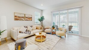 A modern living room with a sofa, armchairs, a coffee table, and a large window with blinds. - Amazing home with outdoor patio, wifi, & close to local attractions near Orlando (Clermont)