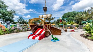 Ein piratenthemen Wasserpark mit Schiff, Rutschen und einer Wasserdüse.