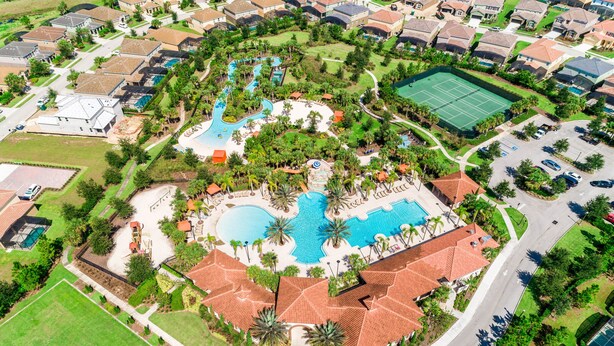 An aerial view of a residential area with a central swimming pool, tennis courts, and a landscaped park. - Modern retreat with private pool, lanai, central AC & gas grill (Davenport)
