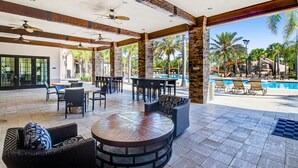 An outdoor patio area with round tables, chairs, and a pool. - Modern retreat with private pool, lanai, central AC & gas grill (Davenport)