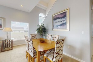 A dining area with a wooden table and patterned chairs, a potted plant, and artwork on the walls. - Deluxe family home with game room, private pool spa, near Disney World - dogs OK (Davenport)
