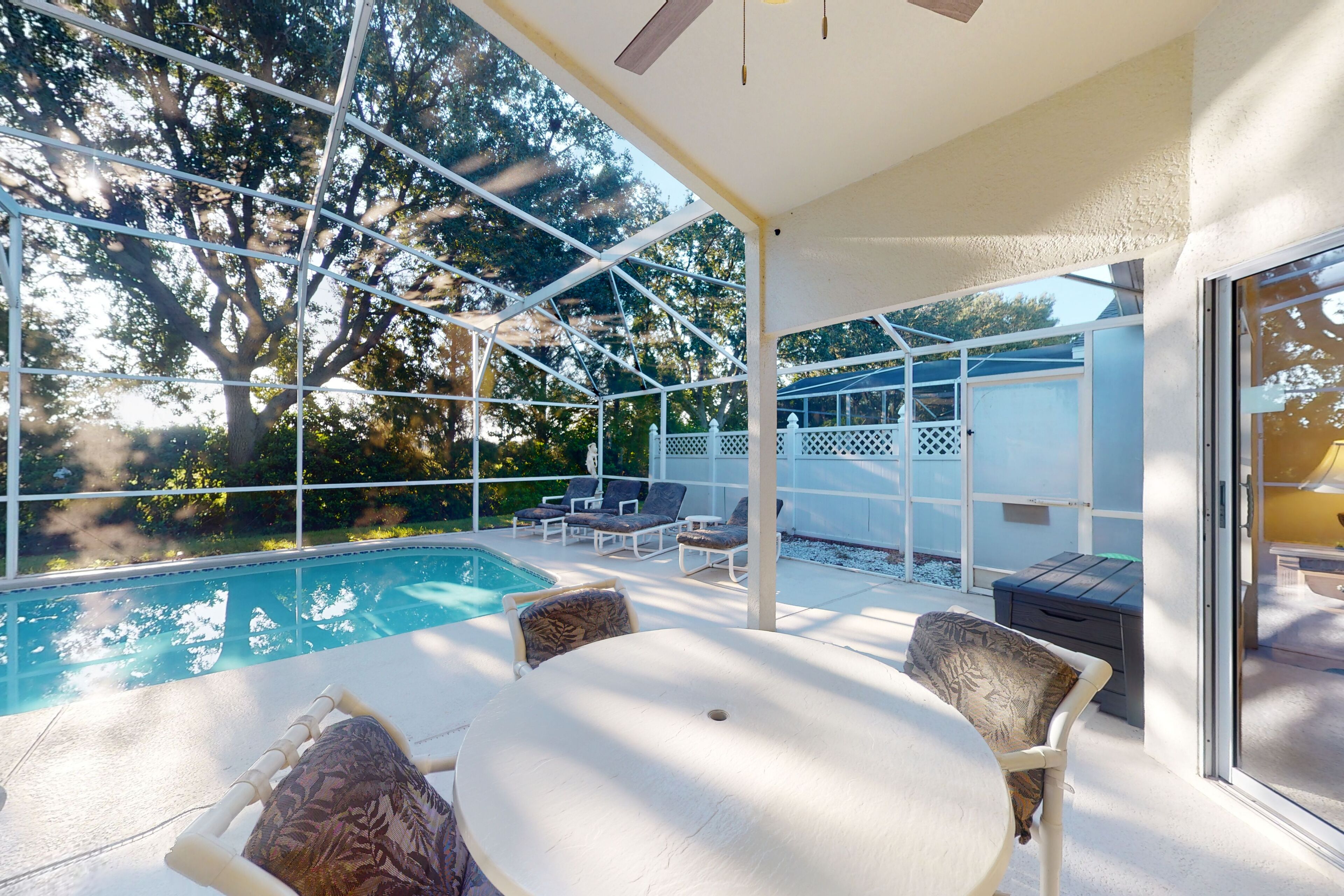 Une terrasse extérieure avec une piscine, des chaises longues et une table.