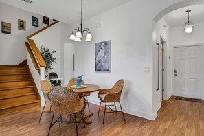A dining area with wicker chairs, a wooden table, and a hanging light fixture. - Mermaid Cove 4BR/3BA Davenport Resort Townhouse (Davenport)