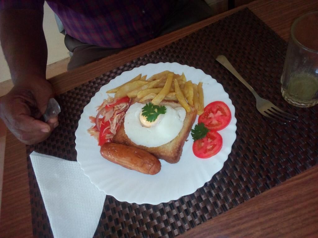 A plate with food, a fork, and a glass on a table.