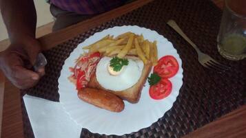 A plate with food, a fork, and a glass on a table.