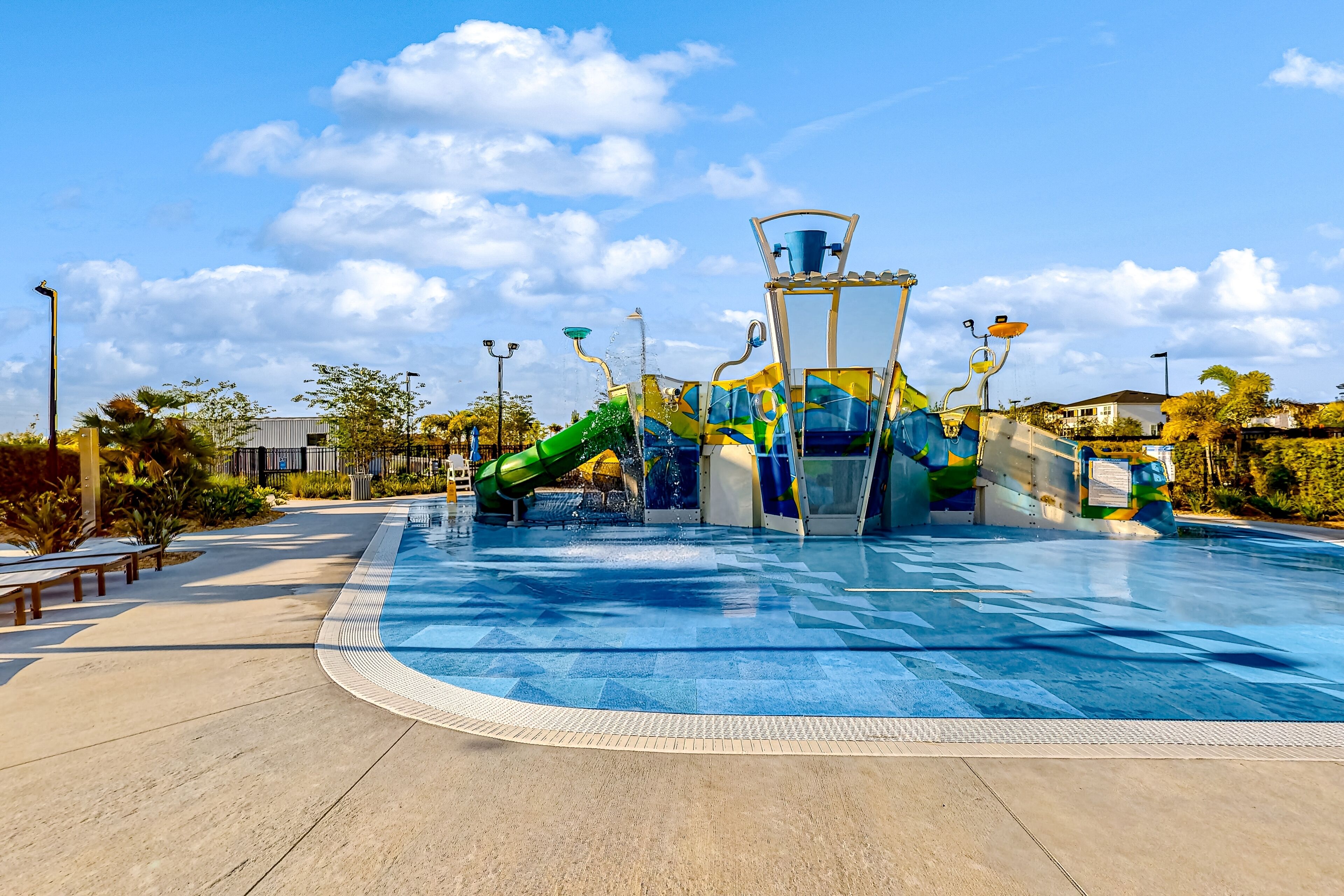 A water park with a large pool, slides, and a colorful play structure.