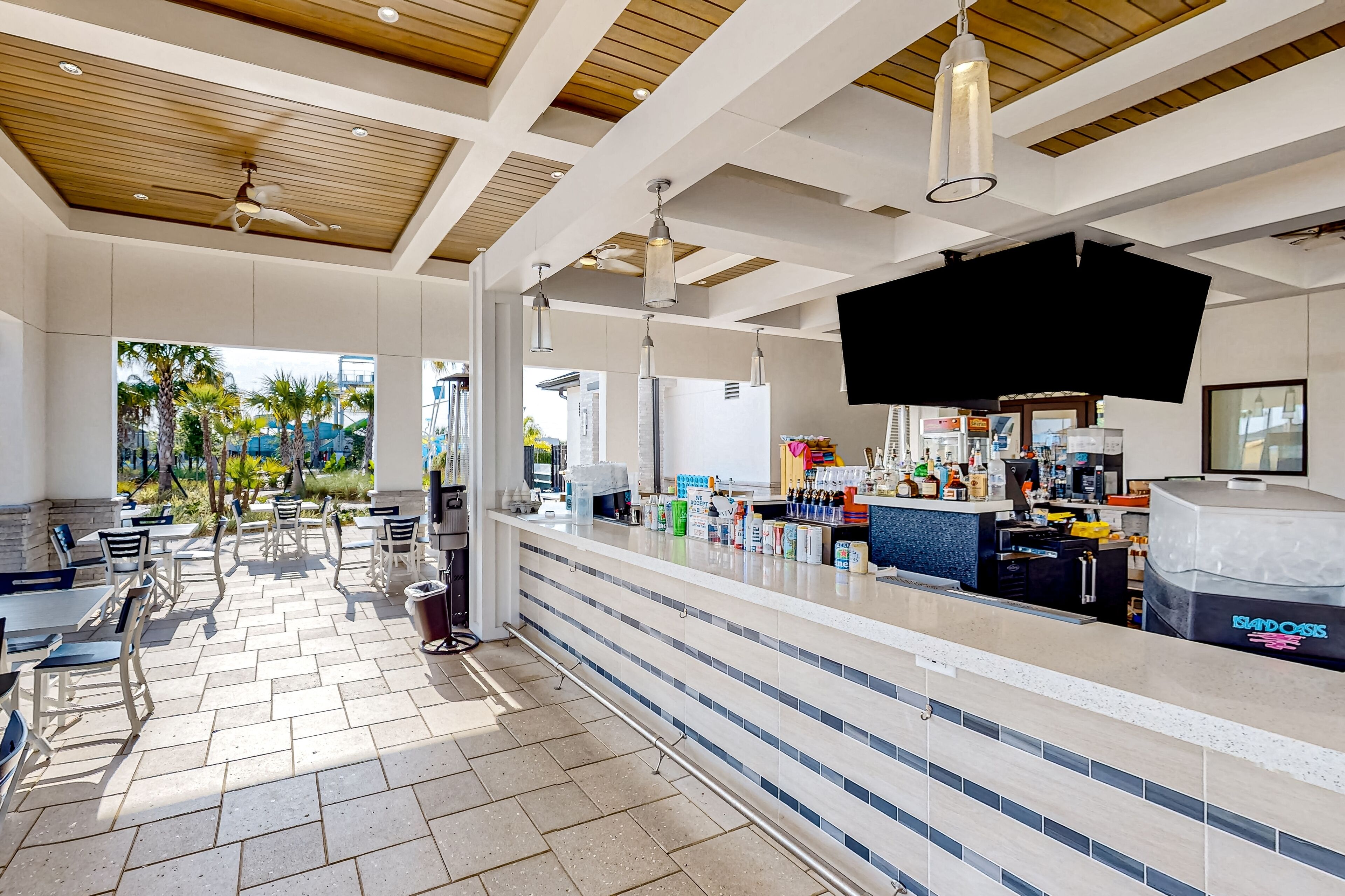 A modern bar area with a counter, seating, and a view of the outdoors.