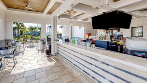 Uma área de bar moderna com balcão, assentos e vista para o exterior.