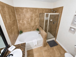 A bathroom with a bathtub, shower, and toilet. - Dog-friendly condo on ground floor with fast WiFi, shared pool, hot tub, & W/D (Davenport)