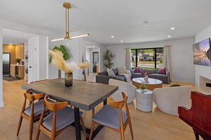 A modern living room with a dining area, a sofa set, a coffee table, and a view of the outdoors. - Spa Retreat: Sauna, Hot Tub & Gym in San Diego (San Diego)