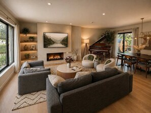 A spacious living room with a fireplace, a grand piano, and a large painting on the wall. - Spa Retreat: Sauna, Hot Tub & Gym in San Diego (San Diego)