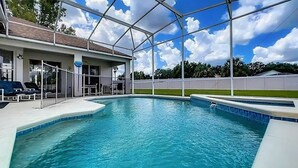 Una piscina con zona cubierta, sillones de descanso y una vista despejada del cielo.