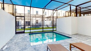 A modern indoor pool with clear glass walls, stone flooring, and a lounge area with a bench. - Two-story townhouse with private pool, screened lanai, washer/dryer (Davenport)