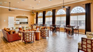 A spacious room with a high ceiling, multiple ceiling fans, and large windows with curtains. - Stylish Family Retreat with Pool near Disney World (Kissimmee)