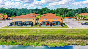 A residential area with houses, a swimming pool, and a body of water. - Stylish Family Retreat with Pool near Disney World (Kissimmee)