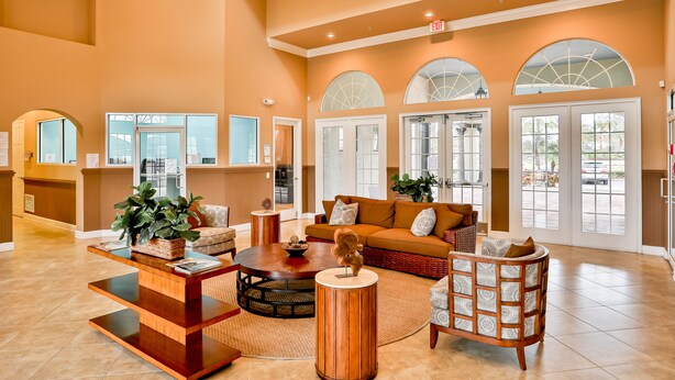 A spacious lobby with a reception desk, seating area, and large windows. - Stylish Family Retreat with Pool near Disney World (Kissimmee)