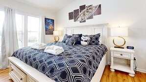 A bedroom with a large bed, bedside tables, a wall clock, and Star Wars artwork. - Resort home with private pool, hot tub, tennis, game room, gym, sports courts (Kissimmee)