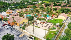 An aerial view of a resort with multiple buildings, a swimming pool, and a parking area. - Dog-friendly townhouse with heated pool, lazy river, hot tub, game room, BBQ (Davenport)