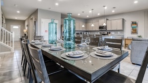 A modern kitchen with a large island, stainless steel appliances, and pendant lighting. - Fun, dog-friendly home with private pool, high-speed WiFi, W/D, & game rooms (Kissimmee)