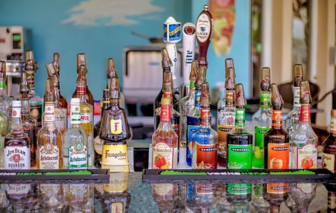 A bar with various bottles of alcohol, including bourbon, whiskey, and liqueurs.