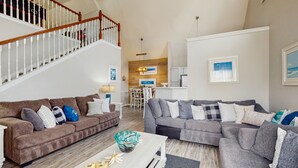 Un salon spacieux avec deux canapés, une table basse et un escalier.