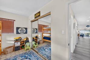 A child's room with a bunk bed, toys, a 'NO WAKE ZONE' sign, and a patterned rug. - Lakefront home with water views, foosball, screened porch, & private W/D (Lake Placid)