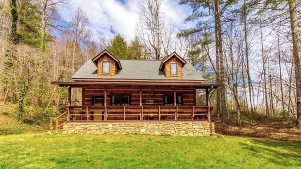A log cabin with a stone foundation, a porch, and two dormer windows. - Log Cabin Mountain Retreat,  2-bedroom cabin in Mills River North Carolina (Horse Shoe)