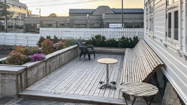 A rooftop patio with wooden flooring, two round tables, and two chairs. - 2 bedroom stunning home in Haugesund (Haugesund)