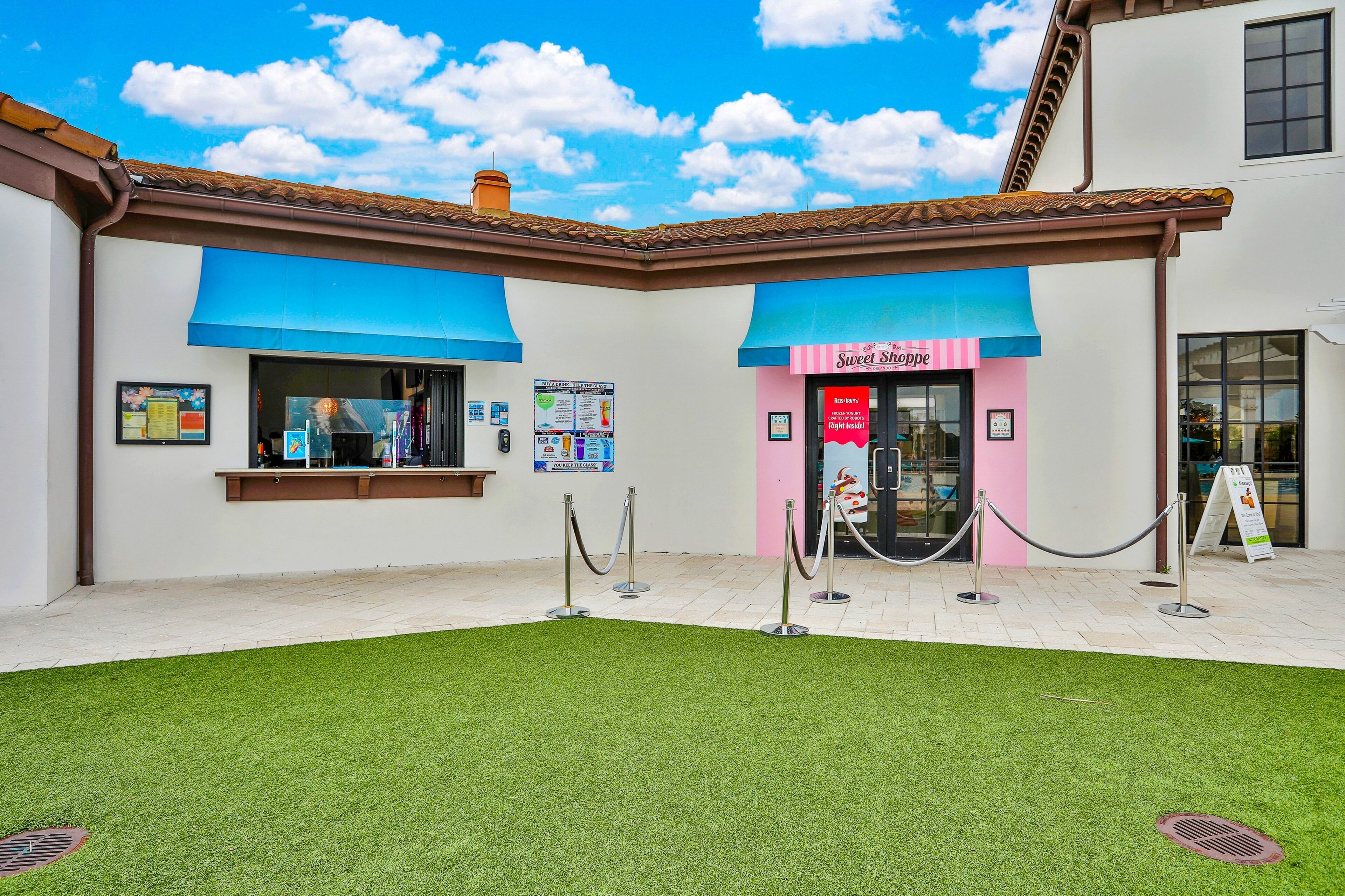Un bâtiment avec un auvent bleu et une enseigne sur laquelle on peut lire « Sweet Shoppe ».