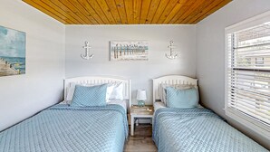 A room with two beds, wooden ceiling, artwork on the wall, and a window with blinds. - Lake June Resort #9 | Condo in Lake Placid (Lake Placid)