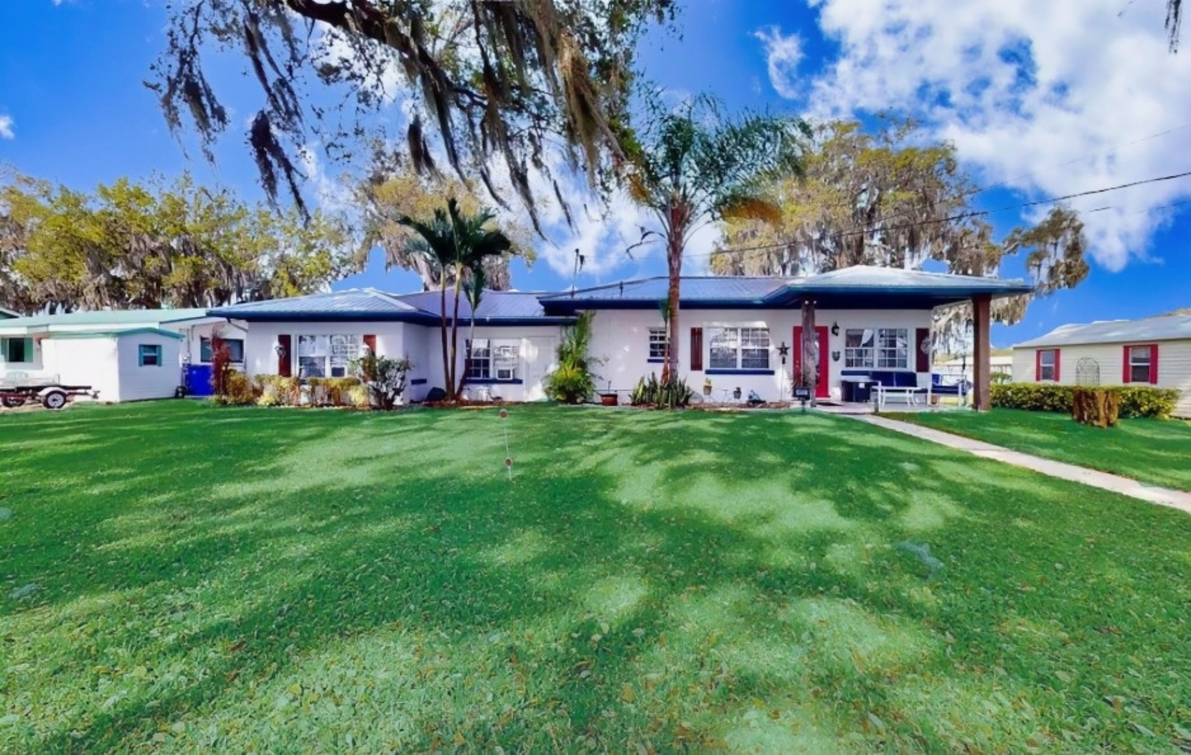 A row of single-story houses with a well-maintained lawn and mature trees.