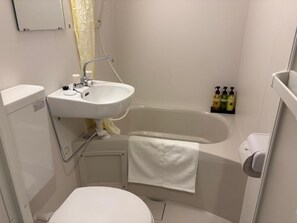 A small, clean bathroom with a white sink, toilet, and bathtub. There are toiletries on the wall and a towel hanging on the tub. - daido garden hotel kyoto (Kyoto)