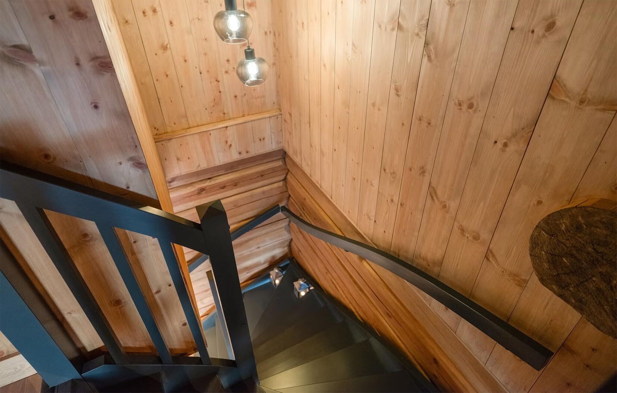A wooden interior with a staircase and a wooden wall.